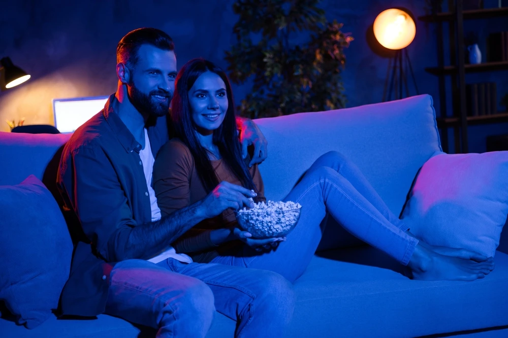 Couple's movie night in with popcorn | Swoosh Finance