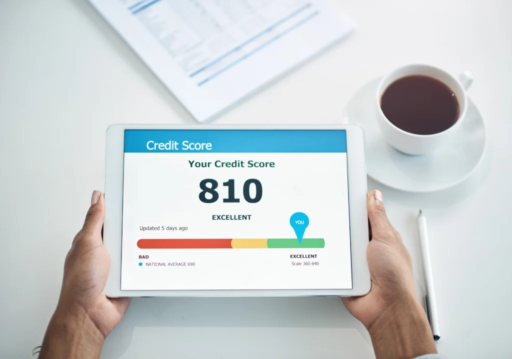 Person holding a tablet displaying their excellent credit score of 810