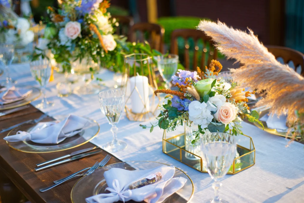 A beautiful table setting for a spring wedding, full of purple and white flowers with greenery and a white tablecloth