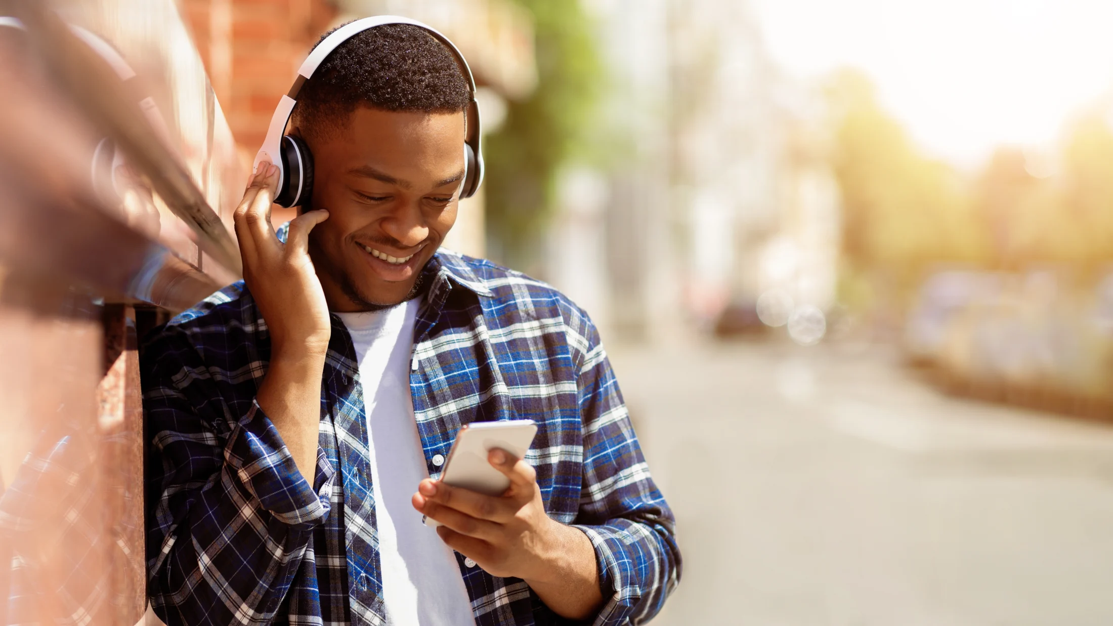 how do payday loans work; young man holding phone and listening to music | Swoosh Finance