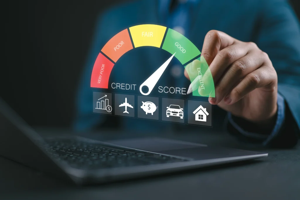 Close up of a person's hand using a laptop with a floating image of a credit score dial pointing to the word good