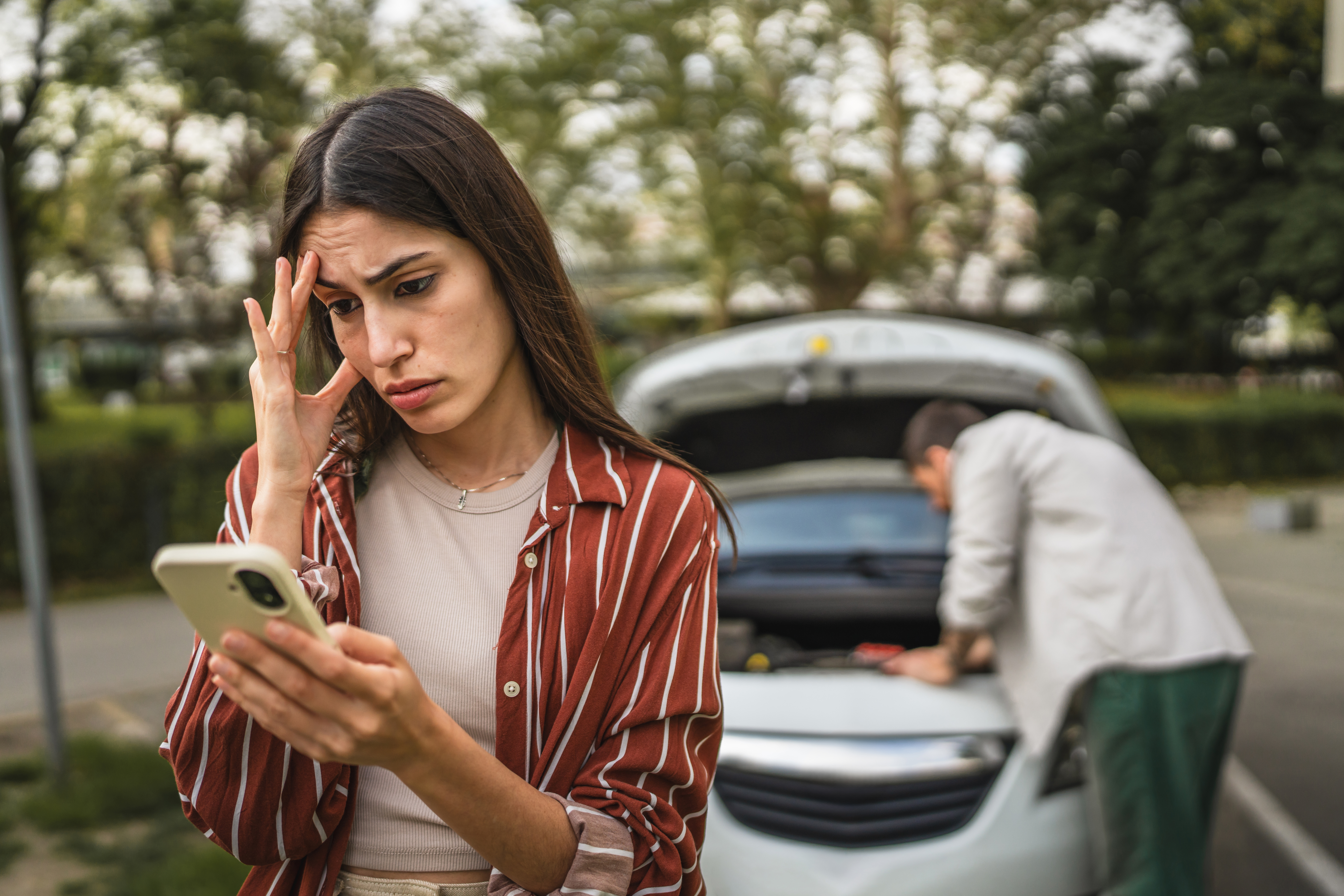 loans against cars; stress woman next to broken down car | Swoosh Finance